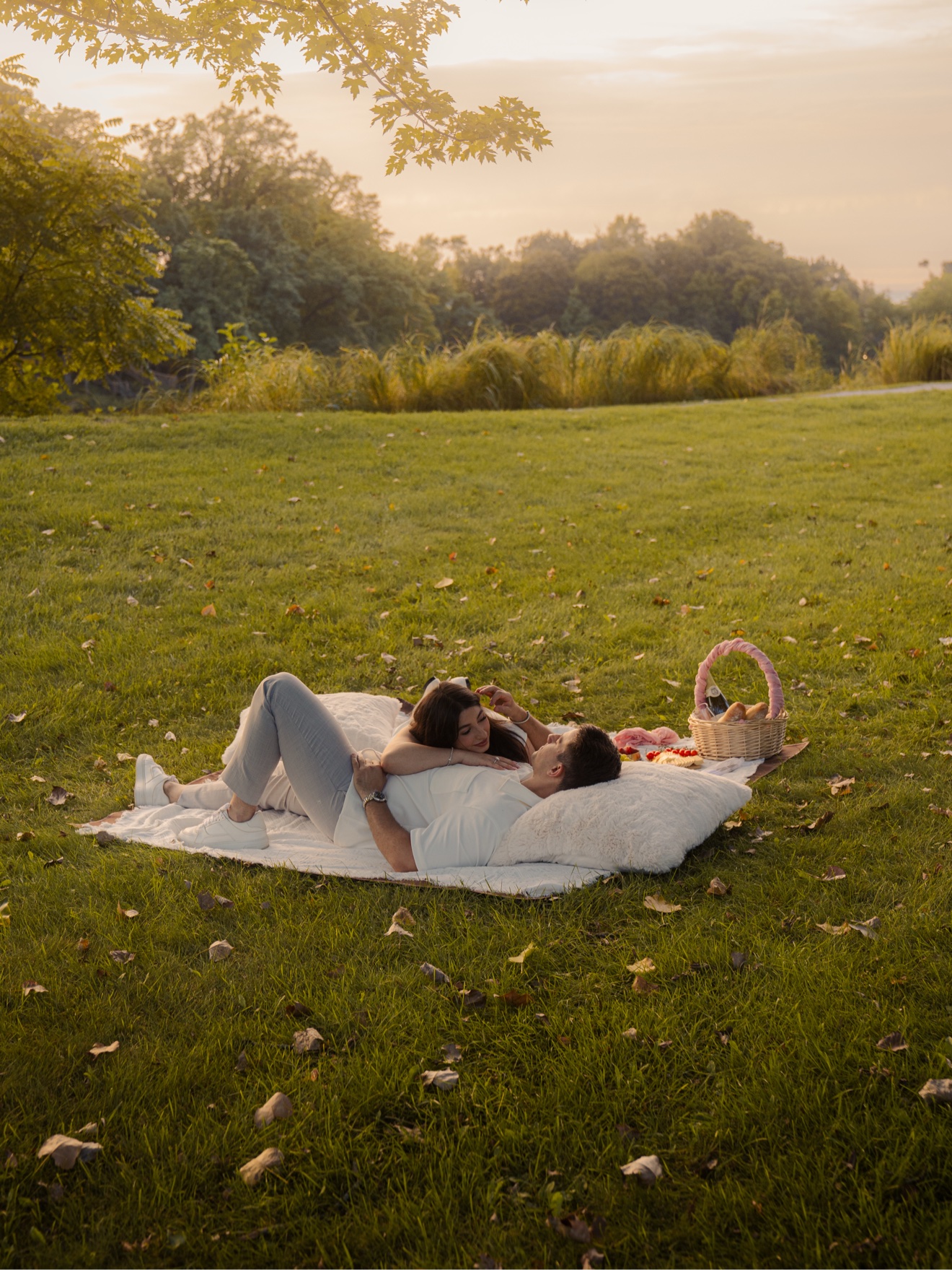 Hassan and Maya relaxing together on a blanket at golden hour