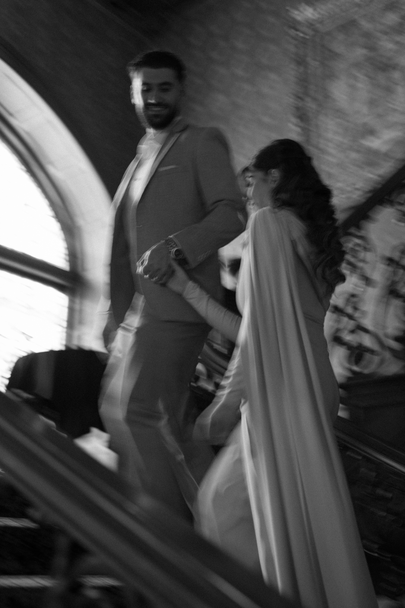 Black-and-white portrait of Hussein and Selena climbing a staircase