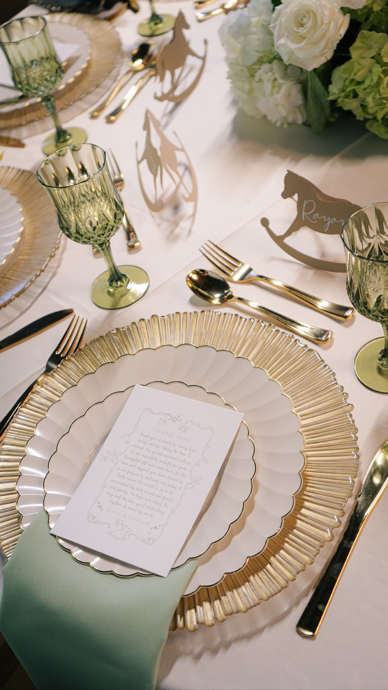 Elegant place setting with green glassware and floral centerpiece